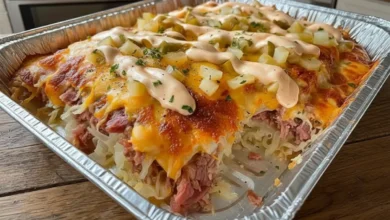 Delicious Keto Reuben Casserole with corned beef, Swiss cheese, sauerkraut, and creamy Russian dressing, baked to perfection and served in a silver dish.