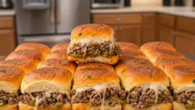 Delicious Philly Cheesesteak Sliders with melted cheese, ground beef, and green peppers on soft slider buns, served in a modern kitchen setting.