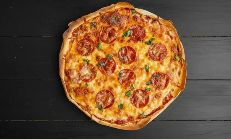 A freshly baked sourdough pizza with pepperoni slices, melted cheese, and basil leaves on a rustic wooden table, showcasing a golden and crispy crust.