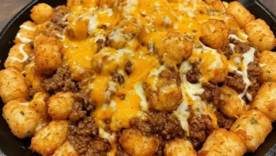 Sloppy Joe Tater Tot skillet with crispy golden tater tots, seasoned ground beef, and melted cheddar cheese in a cast-iron pan.