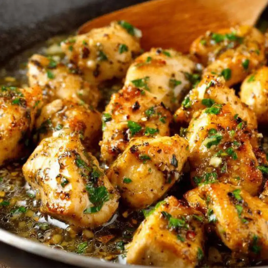 Garlic Butter Chicken pieces cooked in a savory garlic sauce, garnished with fresh parsley, served in a skillet.