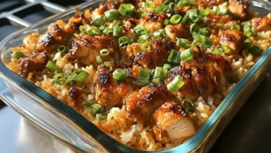 Teriyaki Chicken Casserole in a glass baking dish with fluffy rice, glazed chicken pieces, and sliced green onions on top.