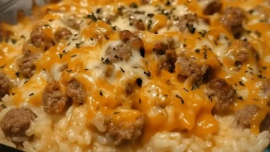 Close-up of Cheesy Ground Beef and Rice Casserole with melted cheese, ground beef, and a sprinkle of herbs on top.