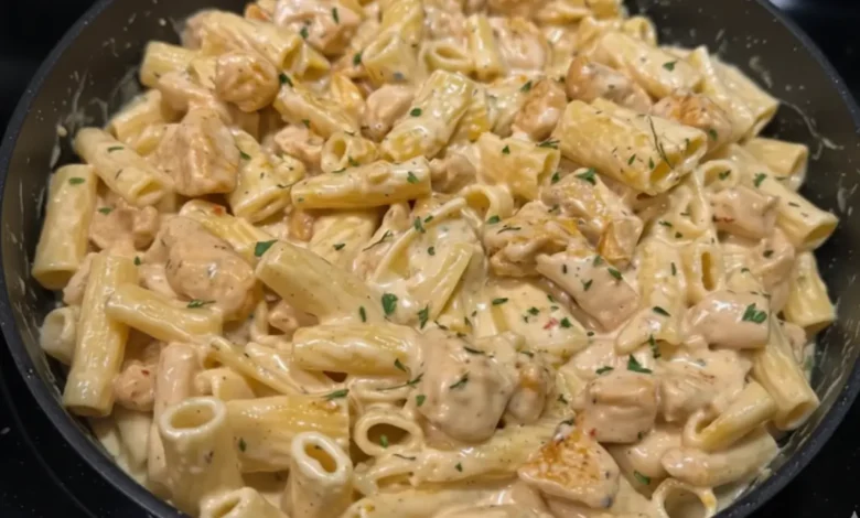 Creamy parmesan garlic chicken pasta with rigatoni and chicken pieces in a skillet, topped with parsley