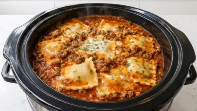 Delicious Crockpot Ravioli Lasagna with melted cheese and ground beef, cooking in a slow cooker.