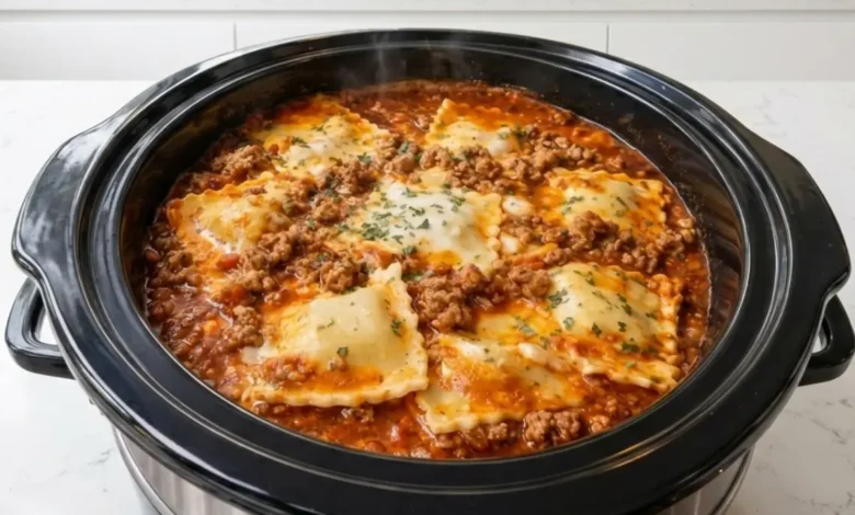Delicious Crockpot Ravioli Lasagna with melted cheese and ground beef, cooking in a slow cooker.